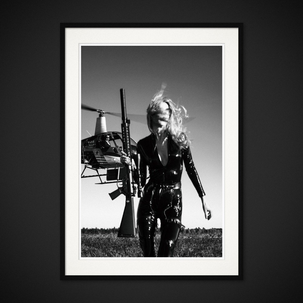 Day At The Office — A rifle, a helicopter and a woman dressed for an extraordinary working day. Framing preview by Albert Pocej; frame not included.