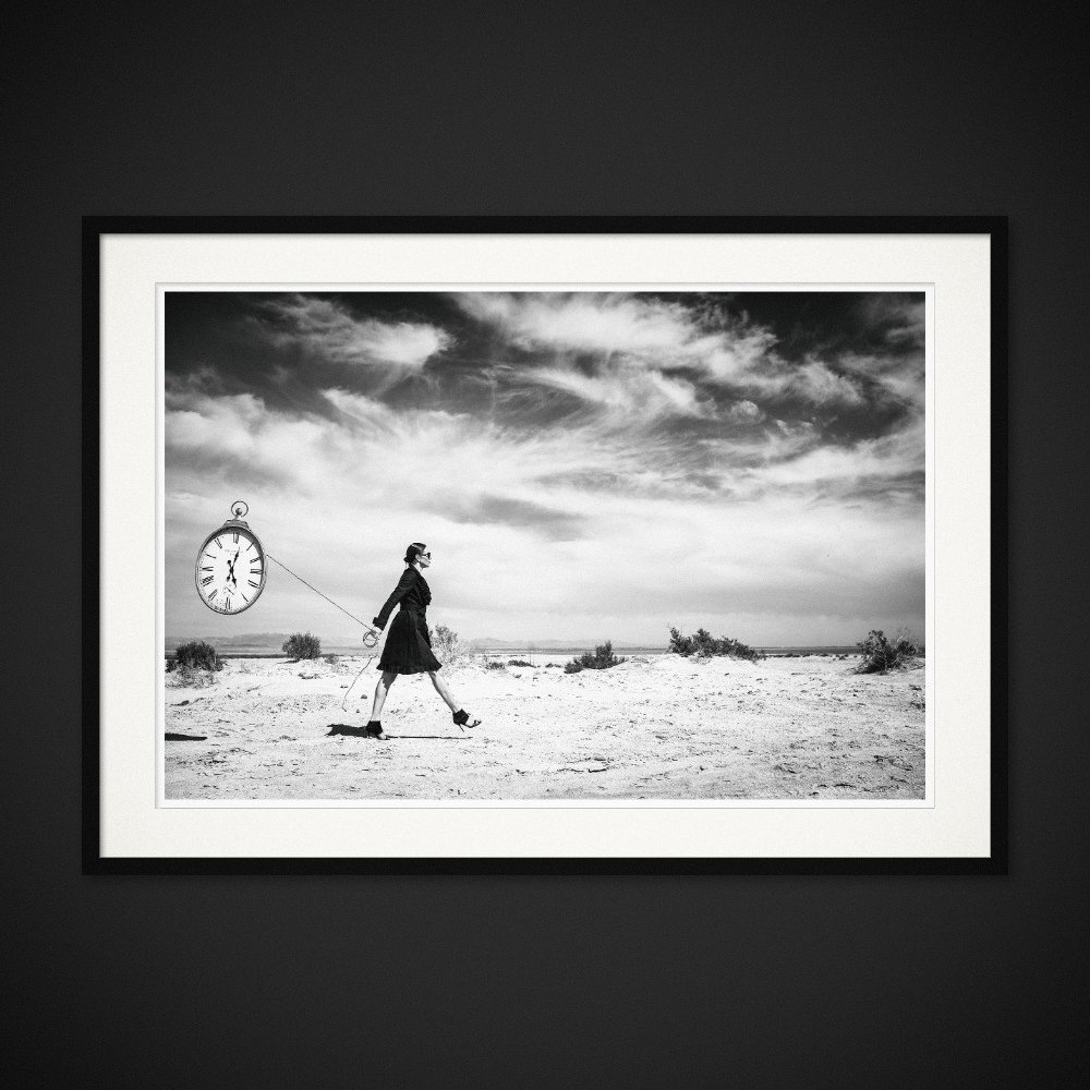 Temporal Baggage — An oversized clock follows a figure across the dry landscape. Framing preview by Albert Pocej; frame not included.