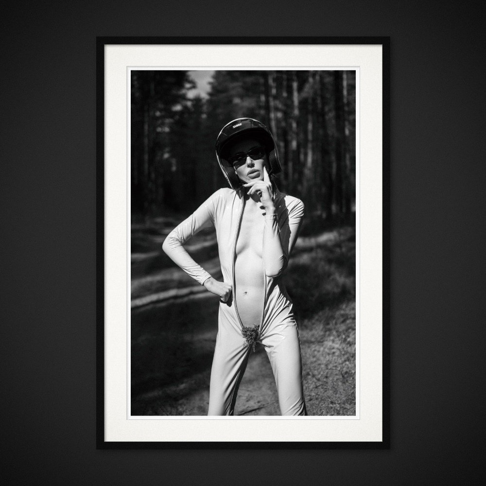 Unzipped Venus — An open racing suit, a helmet and a fragment of the forest. Framing preview by Albert Pocej; frame not included.